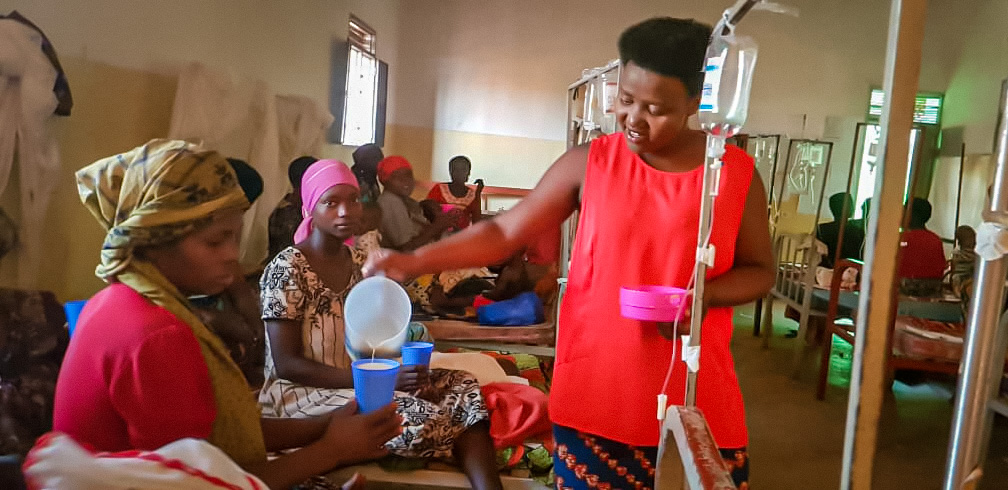 Photo of Aceline distributing porridge as part of the nutrition program